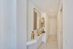 een hal met witte muren en een spiegel bij Vaneymar Home in San Miguel de Abona