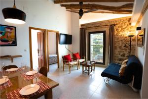 ein Wohnzimmer mit Sofa und Tisch in der Unterkunft LA MUNTANYA - Apartamentos Rural Guadalest in Benimantell