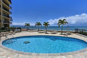 a large blue swimming pool next to the beach at Hololani B204 · HL B204 Beachy Chic Updated OceanFront 2BD in Kahana