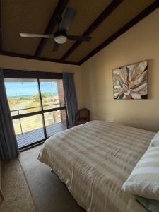 ein Schlafzimmer mit einem Bett und einem Deckenventilator in der Unterkunft Salt & Sand Stay in Singleton