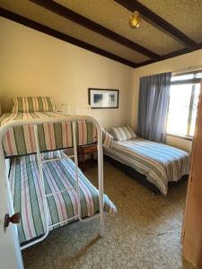 ein Schlafzimmer mit zwei Etagenbetten und einem Fenster in der Unterkunft Salt & Sand Stay in Singleton