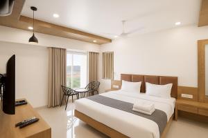 a hotel room with a bed and a television at Hotel The Tulip in Diu