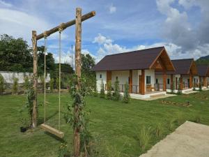 a house with a swing in a yard at Pai Pavilion in Pai