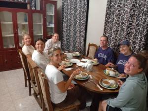 a group of people sitting around a table eating food at The Secret Garden Hotel Moshi in Moshi