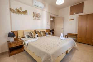 a bedroom with a bed with two swans on it at Georgias Apartments in Haraki +94 photos
