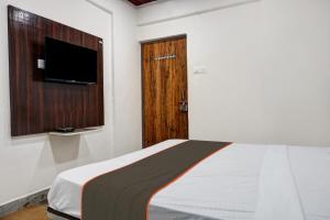 1 dormitorio con 1 cama, TV y puerta en Collection O Aachal Hotel & Lodging, en Phūrsungi 53 fotos más