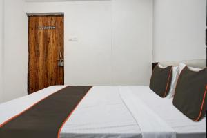 una cama en una habitación con puerta de madera en Collection O Aachal Hotel & Lodging, en Phūrsungi