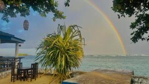 a rainbow over the water with a table and a plant at Royal Sea Wind in Matara +19 photos