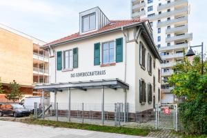 un vieux bâtiment blanc avec une enseigne dessus dans l'établissement Chez Arlette - Neuf - Haut de Gamme - Tram - Proche centre-ville - Tout confort, à Strasbourg 3 autres photos