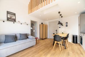 un salon avec un canapé et une table dans l'établissement Chez Arlette - Neuf - Haut de Gamme - Tram - Proche centre-ville - Tout confort, à Strasbourg