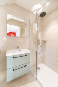 une salle de bain avec un lavabo blanc et une douche dans l'établissement Chez Arlette - Neuf - Haut de Gamme - Tram - Proche centre-ville - Tout confort, à Strasbourg