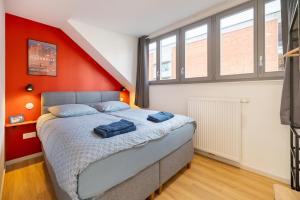 une chambre avec un lit avec un mur orange dans l'établissement Chez Arlette - Neuf - Haut de Gamme - Tram - Proche centre-ville - Tout confort, à Strasbourg