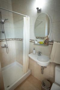 een badkamer met douche, wastafel en spiegel bij Dea Aureum Apartment Limassol in Limassol +31 foto's