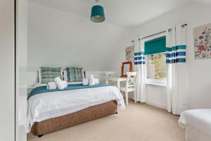 a bedroom with a bed and a table and a window at Hillside in Kyleakin