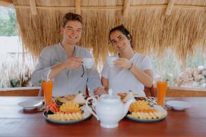 a man and woman sitting at a table with food at Auraya Ella in Ella