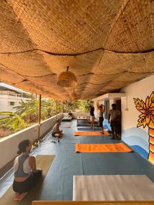 a group of people doing yoga on the floor of a building at Barefoot Hostels, Varkala in Varkala