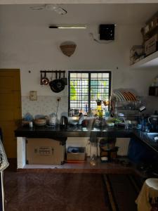 a kitchen with a sink and a counter top at Barefoot Hostels, Varkala in Varkala
