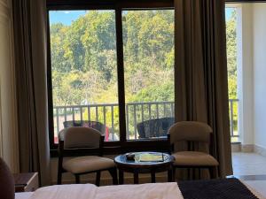 a room with a large window with chairs and a table at The Gooseneck Hotel and Restaurant in Nakraunda