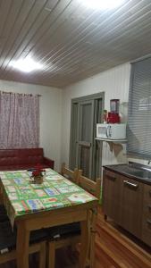 Una cocina con una mesa de madera y una mesa y sillas. en Chalé Paraíso Da Serra 02, en Gramado 6 fotos más