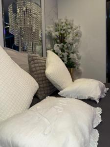 a bed with white pillows and a vase of flowers at Vegas Spa in Limay