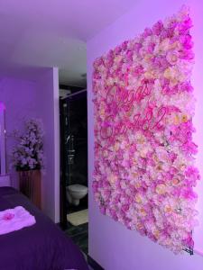 a wall covered in pink flowers in a bedroom at Vegas Spa in Limay