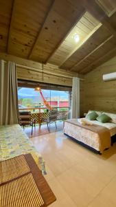 a bedroom with a bed in a room with a view at SUÍTES PRAIA DO ROSA in Imbituba