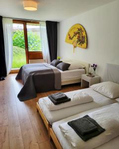 een slaapkamer met drie bedden en een raam bij Garden-Apartment next to the forest, free parking in Schonach