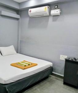 Habitación con cama y aire acondicionado en la pared en HYTON Hotel, en Chennai