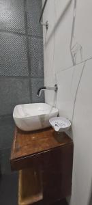 Un baño con un lavabo sobre una mesa de madera. en HYTON Hotel, en Chennai