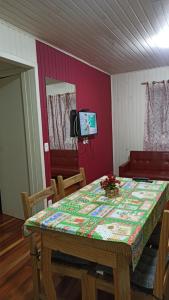 a dining room with a table and a tv at Chalé Paraíso Da Serra 02 in Gramado