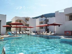 ein Schwimmbad mit Liegestühlen und Sonnenschirmen vor einem Gebäude in der Unterkunft Esperides Hotel in Limenas