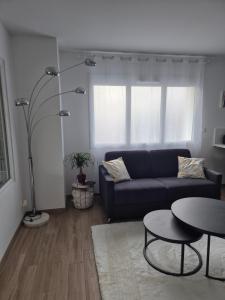 una sala de estar con un sofá y una mesa en Gîte Un instant de rêve à Dorlisheim, piscine intérieure chauffée, sauna, en Dorlisheim