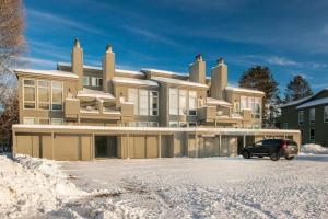 a large house with a car parked in the snow at RMR: Wheatgrass 2212 Condo in The AspensWilsonWY in Wilson