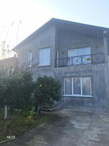 a gray house with a balcony on top of it at Tsitadel in Zugdidi