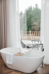 eine weiße Badewanne in einem Zimmer mit Fenster in der Unterkunft Wyndham Residences Aqkol in Aqköl