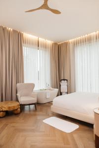 ein Schlafzimmer mit einem großen Bett, einer Badewanne und einem Stuhl in der Unterkunft Wyndham Residences Aqkol in Aqköl + 81 Fotos