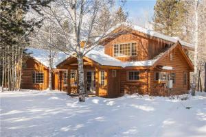 una cabaña de troncos en la nieve con nieve en RMR: Teton View Cabin Home in WilsonWY, en Wilson