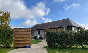 a house with a wooden fence in front of it at L'étable de Keriven in La Chapelle-Neuve