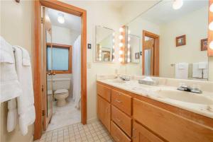 a bathroom with a sink and a toilet and a mirror at RMR: Stock House in Teton Village in Teton Village +22 photos