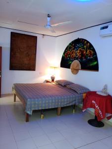 a bedroom with a bed and a painting on the wall at Villa Onus in Aluthgama