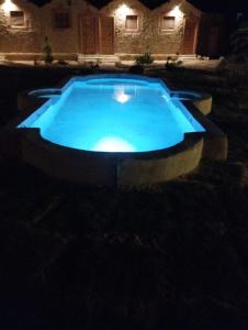 a large blue swimming pool in a yard at night at Siwa Serenity Home in Siwa