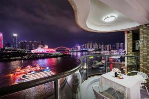 a balcony with a view of a river and a cruise ship at Deptour Riverview aparment-ChaoTianMen in Chongqing