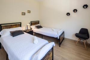 a room with two beds and a chair in it at Beautiful house 15 min away from Bilbao in Llodio