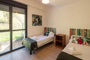 a bedroom with two beds and a window at Beautiful house 15 min away from Bilbao in Llodio +14 photos