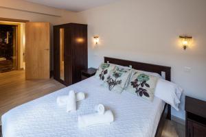 a bedroom with a white bed with towels on it at Beautiful house 15 min away from Bilbao in Llodio