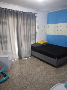 a bedroom with a black bed with a yellow pillow at Cop 30 in Belém