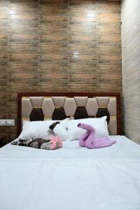 two stuffed animals are laying on a bed at Hotel Bhagirath in Mumbai