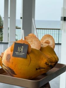 亭可马里Trinco Diyash Beach Hotel的盘子里堆着一堆水果，旁边有个牌子。