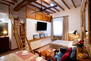 ein Wohnzimmer mit einem Bett und einem Fernseher in der Unterkunft LA MUNTANYA - Apartamentos Rural Guadalest in Benimantell + 17 Fotos