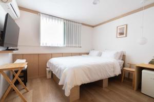 a small bedroom with a bed and a television at stay105행궁 in Suwon